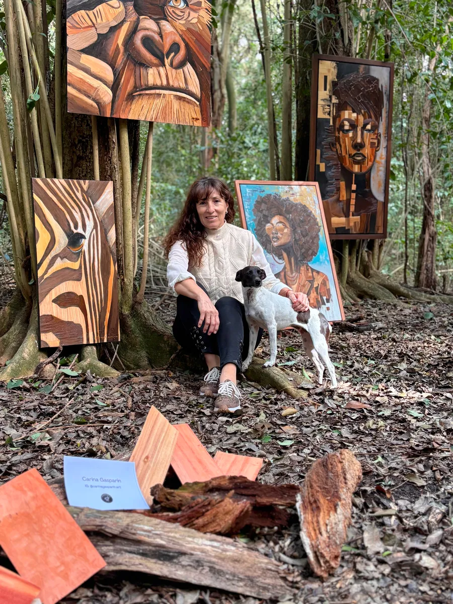 Carina Gasparin con su perra entre sus obras, en la muestra de Estancia La Margarita